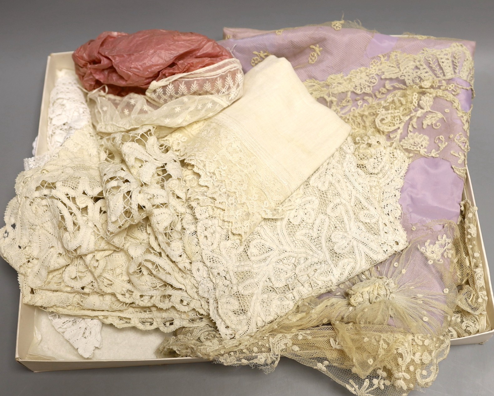 A Brussels mixed needlepoint lace cover, damaged a wide length of tape lace trim a similar collar, a later Honiton collar, a Scottish white worked hankie needlepoint baby bonnet and small Brussels collar